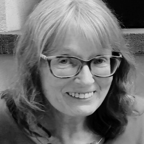 Eine Frau mit Brille lächelt in die Kamera