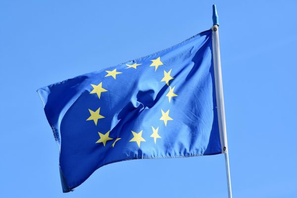 Die blaue Fahne der Europäischen Union vor blauem Himmel