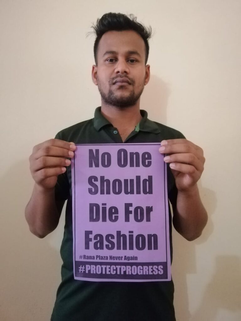 Ein junger Mann hält ein lilafarbenes Schild in die Kamera. Darauf steht: "No One Should Die For Fashion"