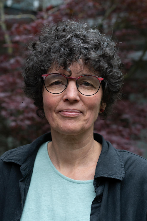 Ein Netzwerk, das Mut macht 4 Eine Frau mit Brille und Locken steht vor einer Wand