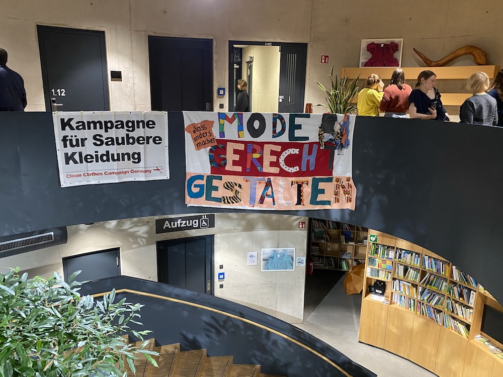 Ein Netzwerk, das Mut macht 9 Von einem Treppengeländer im Inneren hängen zwei Plakate aus Stoff