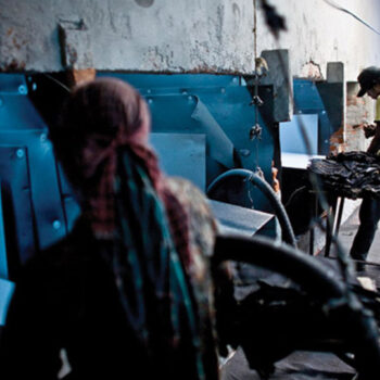 Von der Arbeitshose zum Fast-Fashion-Produkt: Denim-Produktion in der Türkei 1 Zwei Männer stehen in einer Werkhalle.